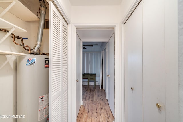 corridor with water heater and light hardwood / wood-style flooring