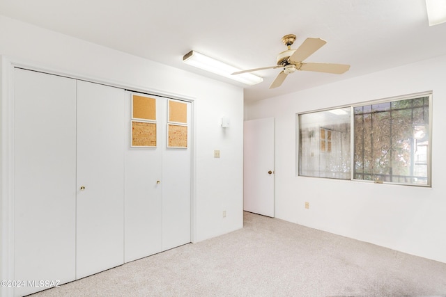 unfurnished bedroom featuring light carpet, a closet, and ceiling fan