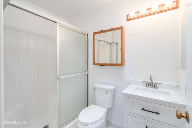 bathroom with a shower with door, vanity, and toilet