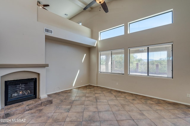 unfurnished living room with a fireplace, plenty of natural light, and tile patterned flooring