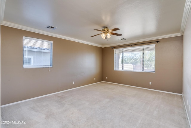 spare room featuring light colored carpet, ceiling fan, and ornamental molding