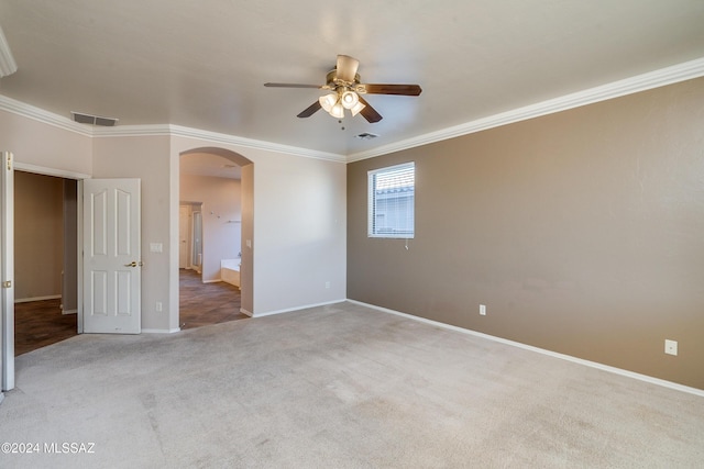 spare room featuring light carpet, ceiling fan, and crown molding