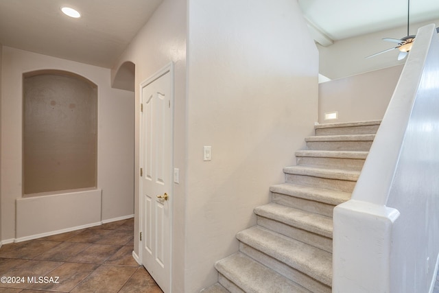 staircase featuring ceiling fan