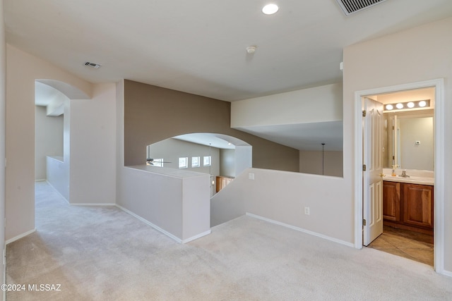 corridor featuring light colored carpet