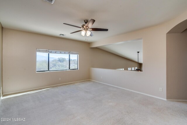 carpeted empty room featuring ceiling fan and vaulted ceiling