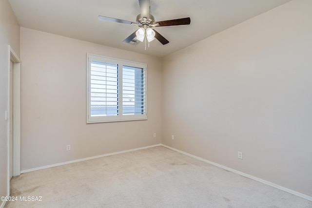 spare room with ceiling fan and light carpet