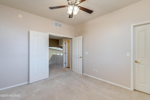 unfurnished bedroom featuring light colored carpet and ceiling fan