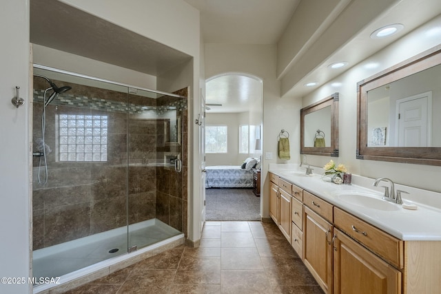 bathroom featuring tile patterned flooring, vanity, and a tile shower