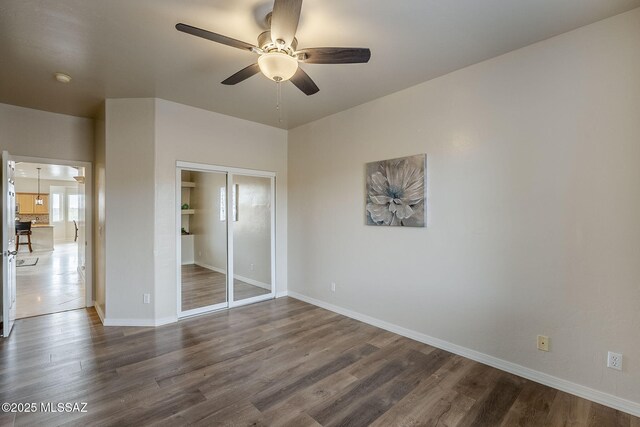 spare room with built in shelves, ceiling fan, and hardwood / wood-style flooring