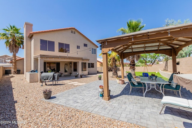 rear view of house featuring a gazebo and a patio