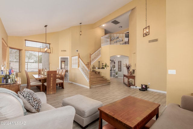 living room with high vaulted ceiling and an inviting chandelier