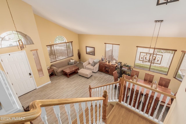 living room with vaulted ceiling, a chandelier, and wood-type flooring