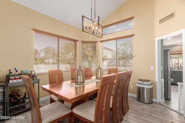 dining area with plenty of natural light, lofted ceiling, and a chandelier