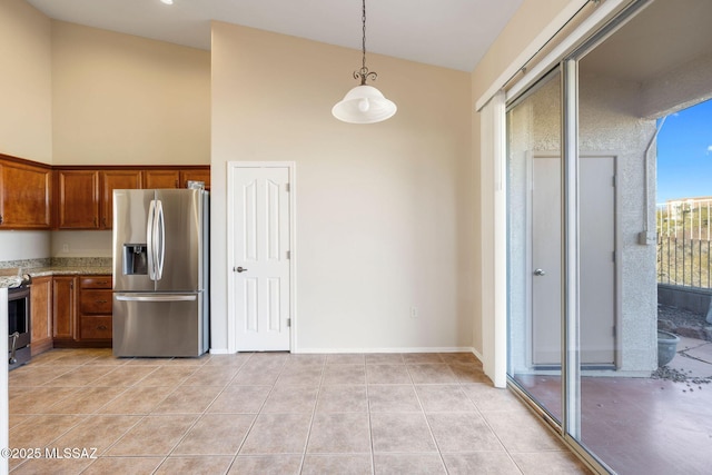 kitchen with light tile patterned floors, appliances with stainless steel finishes, hanging light fixtures, high vaulted ceiling, and light stone countertops