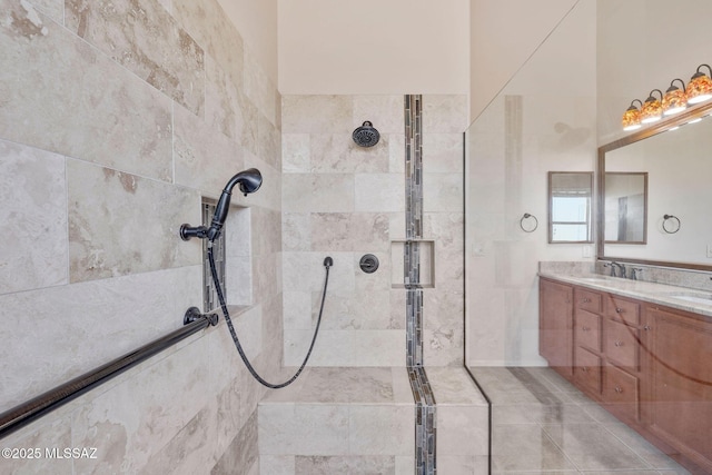 bathroom with a tile shower and vanity