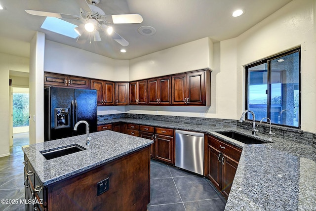 kitchen featuring black fridge with ice dispenser, stainless steel dishwasher, a kitchen island with sink, and sink