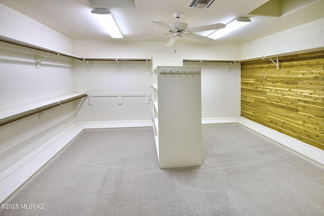 walk in closet featuring light colored carpet and ceiling fan