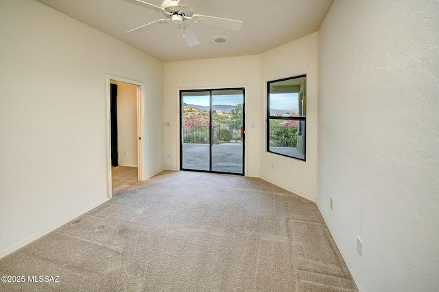 empty room featuring light carpet and ceiling fan