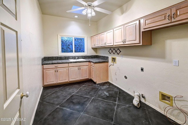 clothes washing area featuring hookup for a washing machine, ceiling fan, dark tile patterned floors, gas dryer hookup, and sink