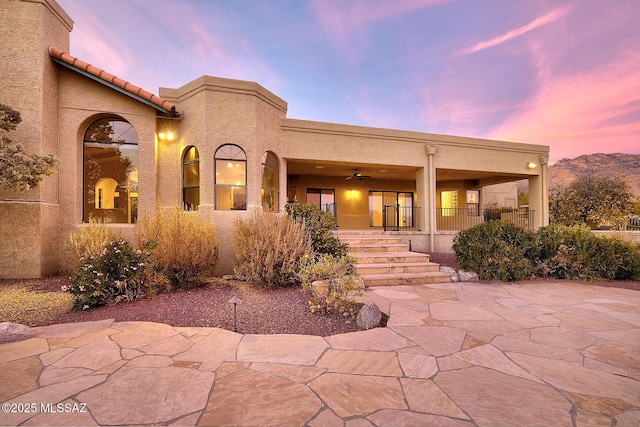 view of front of home with a patio area, ceiling fan, and a porch