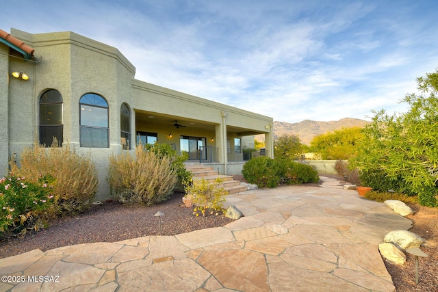 exterior space featuring a mountain view and ceiling fan