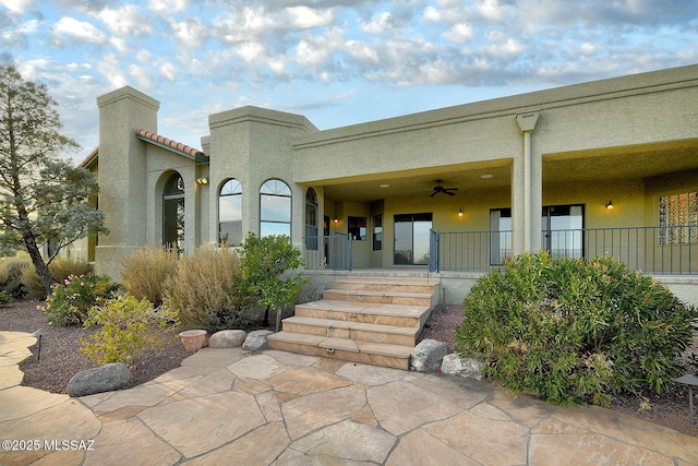 property entrance with ceiling fan and a porch