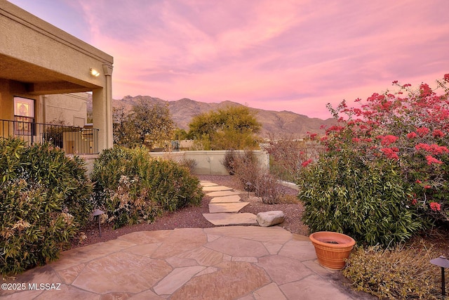 view of patio featuring a mountain view and fence