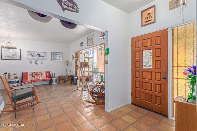 foyer entrance with an inviting chandelier and tile patterned floors