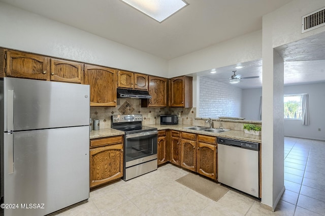 kitchen with sink, ceiling fan, light tile patterned floors, appliances with stainless steel finishes, and tasteful backsplash