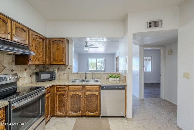 kitchen with backsplash, sink, ceiling fan, appliances with stainless steel finishes, and extractor fan