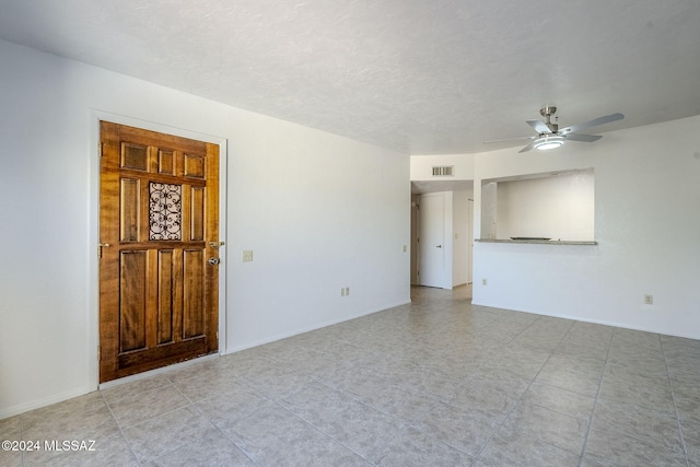 empty room with a textured ceiling and ceiling fan