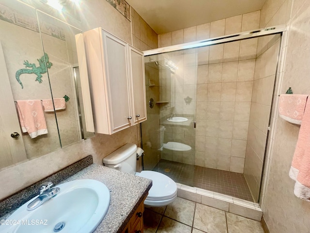 bathroom featuring tile patterned floors, a shower with door, vanity, and toilet