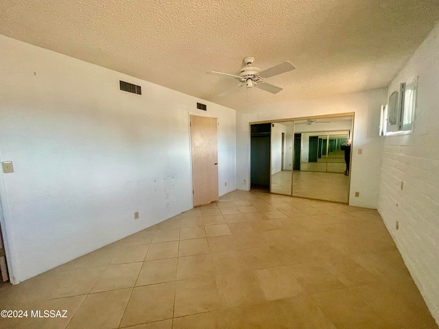 tiled spare room featuring ceiling fan and a textured ceiling