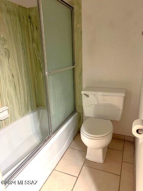 bathroom featuring shower / bath combination with glass door, tile patterned floors, and toilet