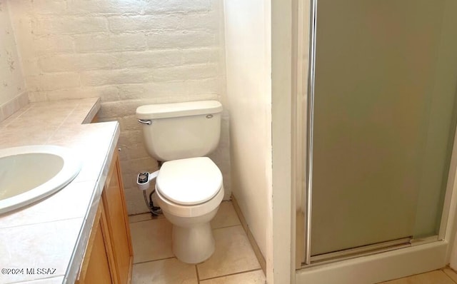 bathroom with walk in shower, brick wall, vanity, tile patterned flooring, and toilet