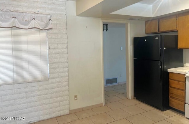 kitchen featuring black refrigerator and light tile patterned flooring