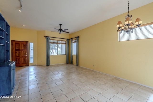 tiled spare room with ceiling fan with notable chandelier