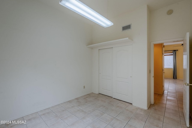 unfurnished bedroom with a closet and light tile patterned flooring