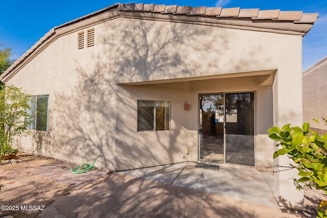 back of property with a patio