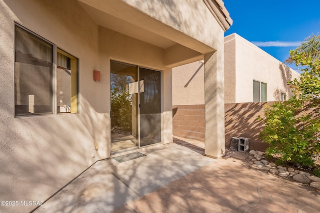 view of exterior entry featuring a patio