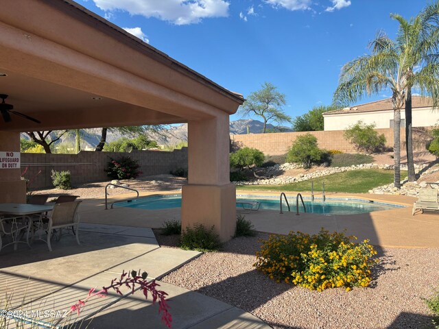 view of patio / terrace featuring a fenced in pool and ceiling fan