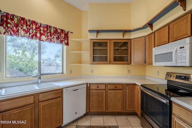 kitchen featuring light tile patterned flooring, sink, and white appliances