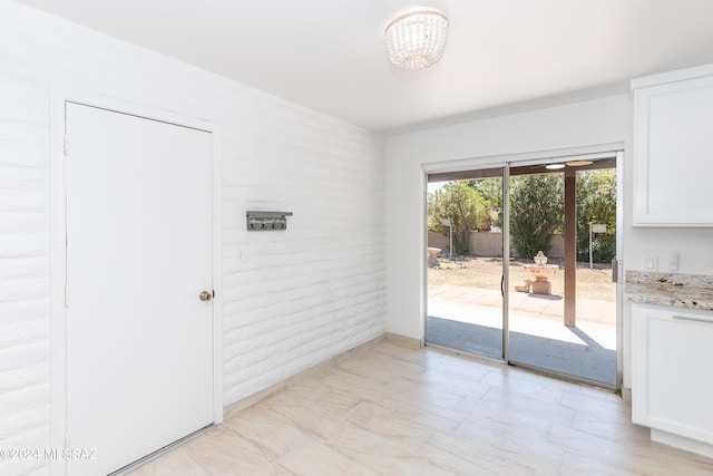 doorway featuring brick wall