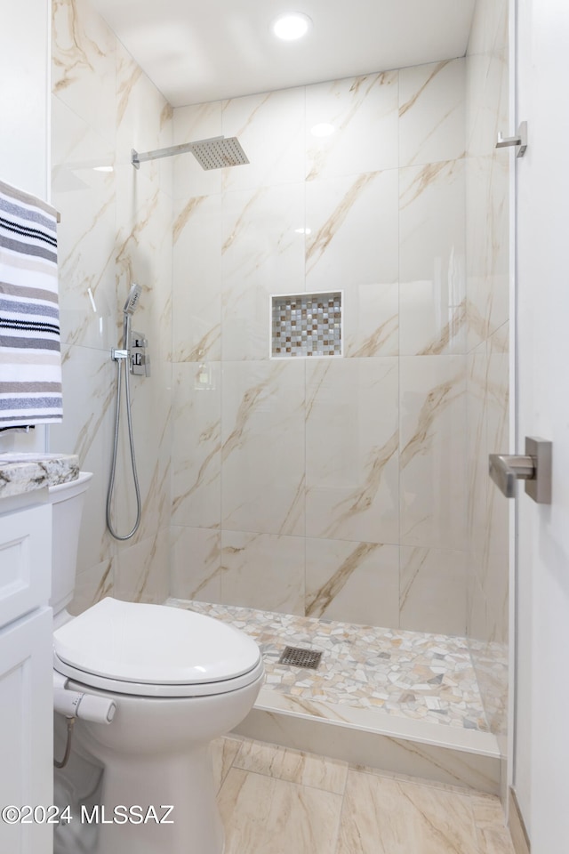 bathroom featuring tiled shower and toilet