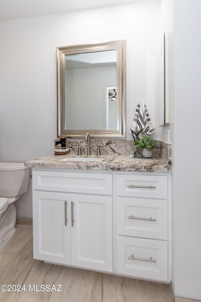 bathroom with hardwood / wood-style flooring, vanity, and toilet