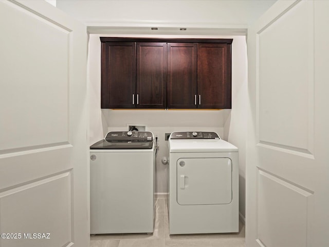 washroom with cabinets and washer and dryer