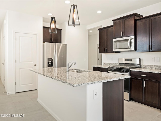 kitchen featuring a center island with sink, appliances with stainless steel finishes, sink, and light stone countertops