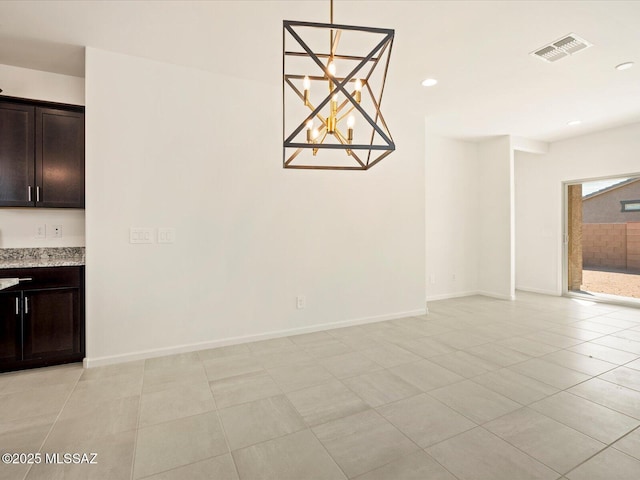 unfurnished dining area featuring a notable chandelier and light tile patterned floors