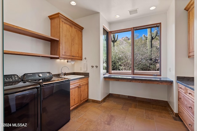 laundry area featuring cabinets, independent washer and dryer, and sink