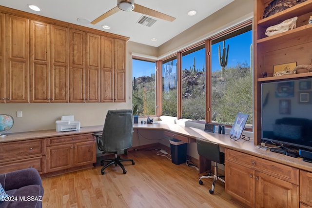 office area with built in desk, light hardwood / wood-style flooring, and ceiling fan